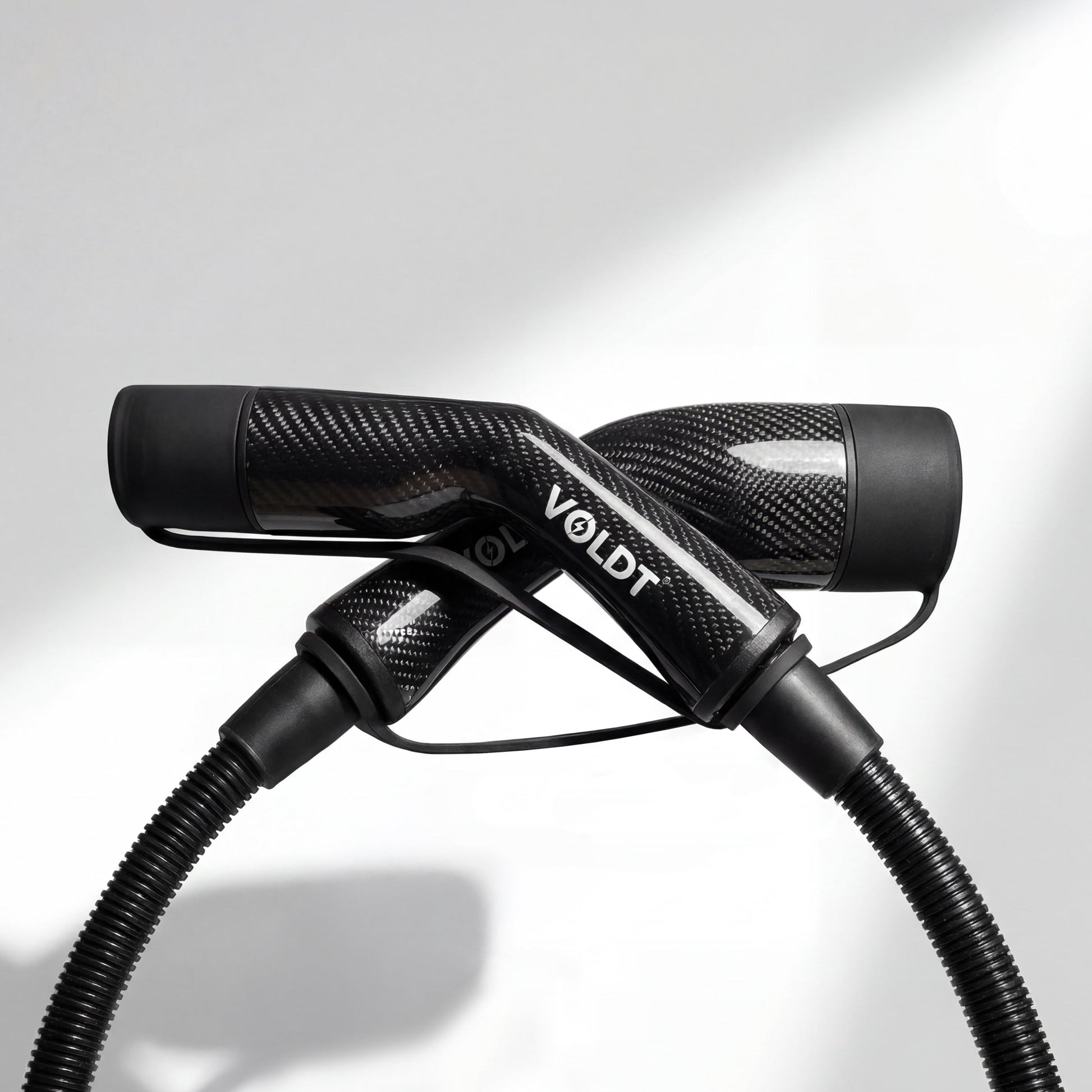 Stijlvol elektrisch laden met de lichtgewicht Voldt carbon fibre laadkabel bij een sportauto.